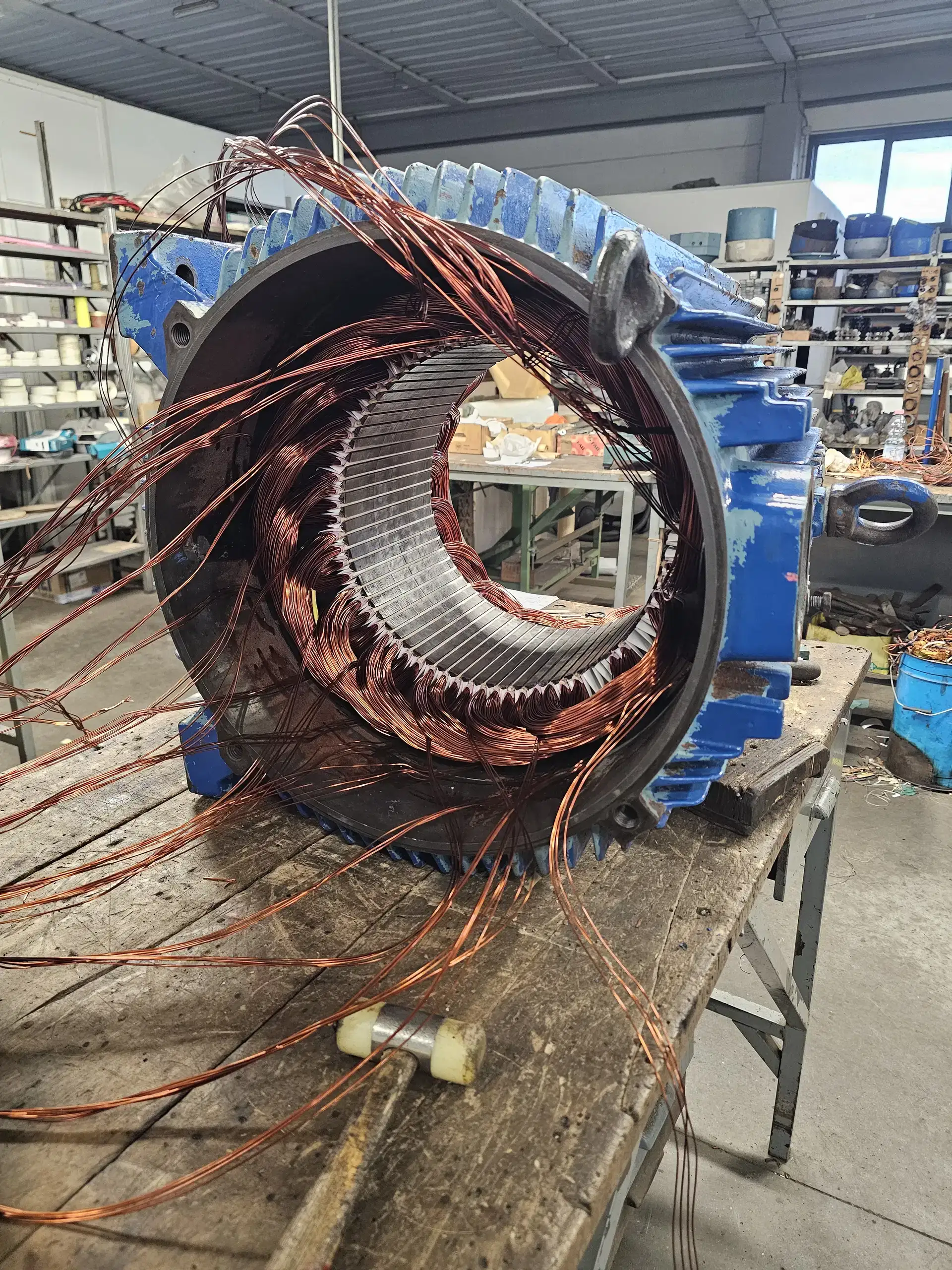 Statore di un motore elettrico in fase di riavvolgimento sul banco dell'officina